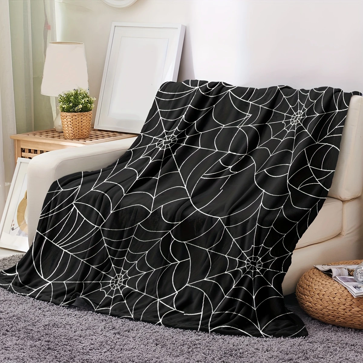 Spiderweb print detail on black fleece blanket