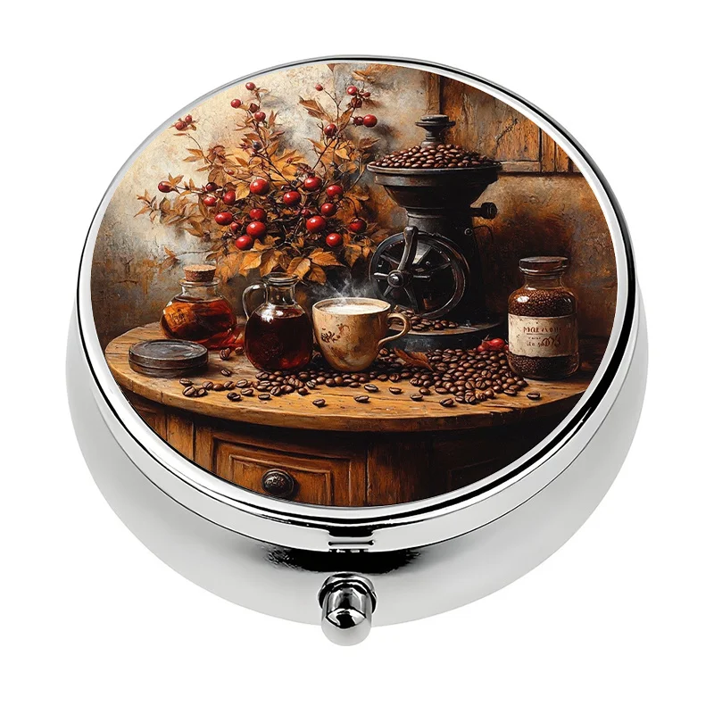 A single portable pill box, divided into three sections, features a painting of a rural coffee still life, including coffee beans and a grinder, making it perfect for carrying in a wallet or bag. This decorative pill box is a unique gift.