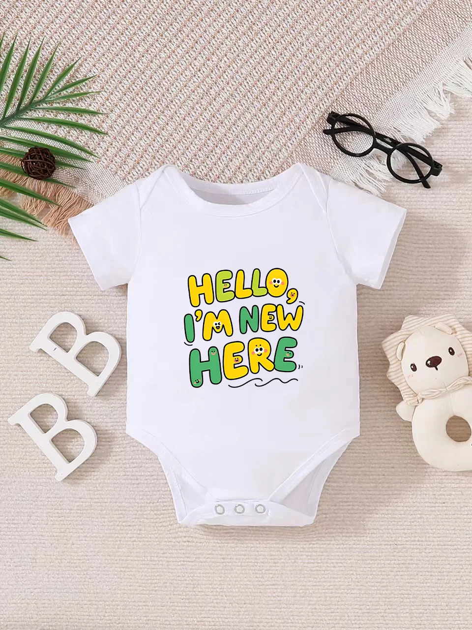 Playful letter-printed baby short-sleeve triangle bodysuit. Button closure for easy dressing, machine washable