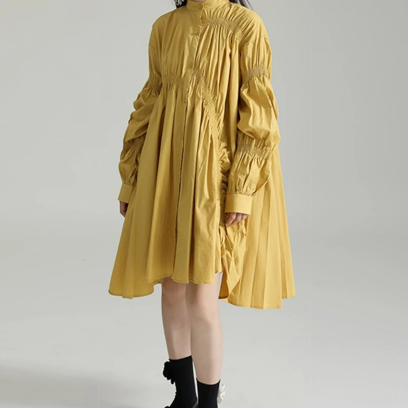 Modna sukienka koszulowa w stylu trendsetterów, luźna, z nieregularnymi plisowanymi bufiastymi rękawami i szerokim dołem.