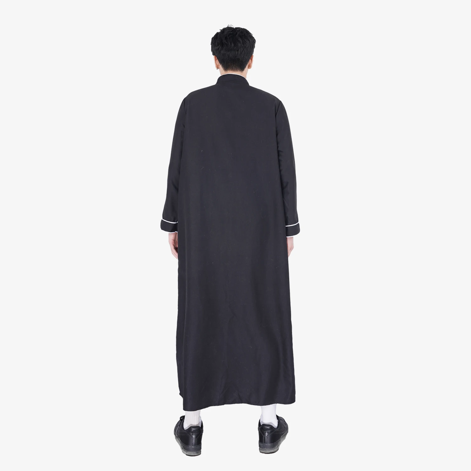 Un abito arabo nero in pizzo stampato bianco, un abito musulmano del Ramadan