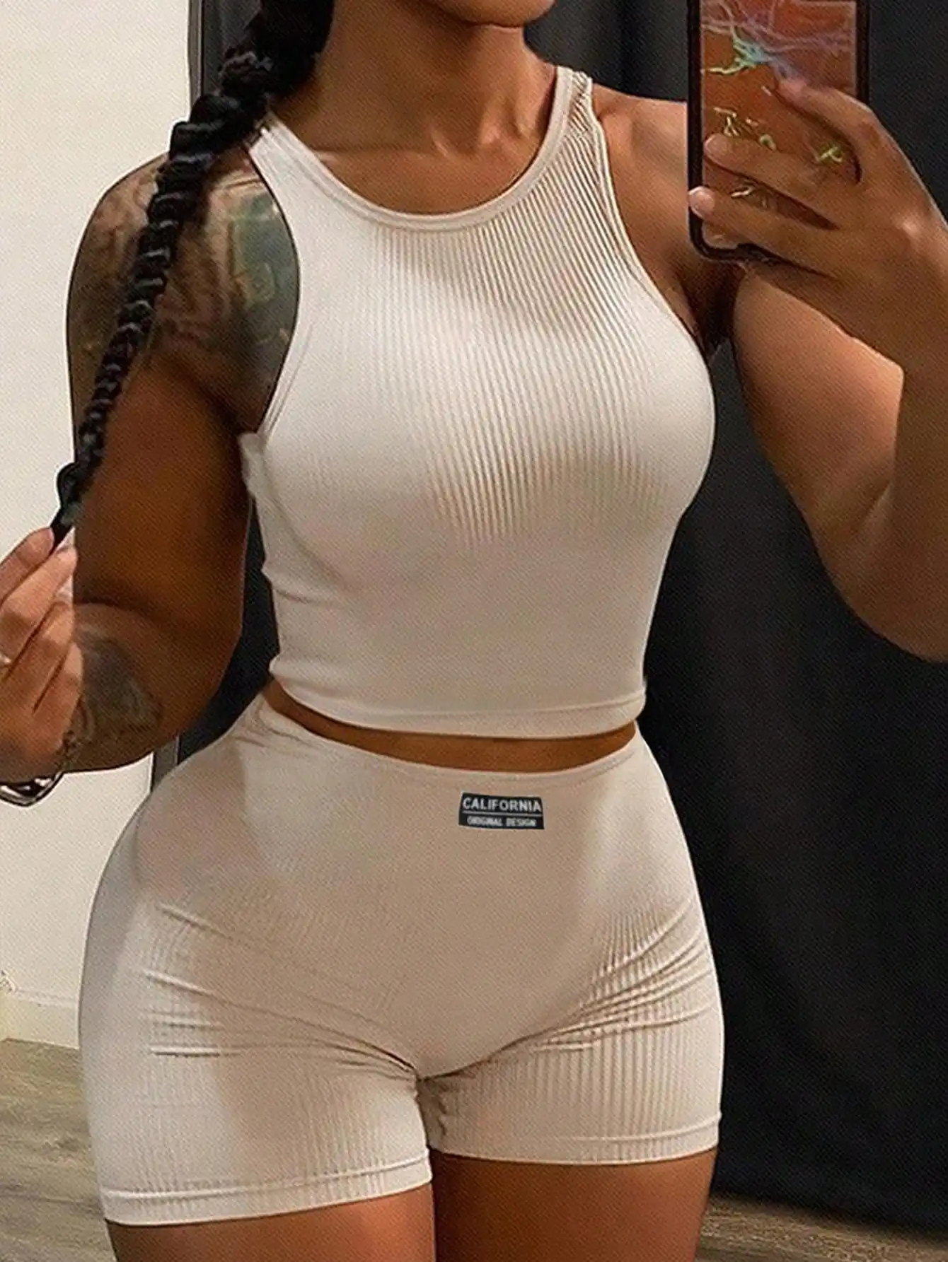 

Женский комплект из двух предметов: укороченный топ без рукавов из ребристой ткани и облегающие шорты с высокой талией