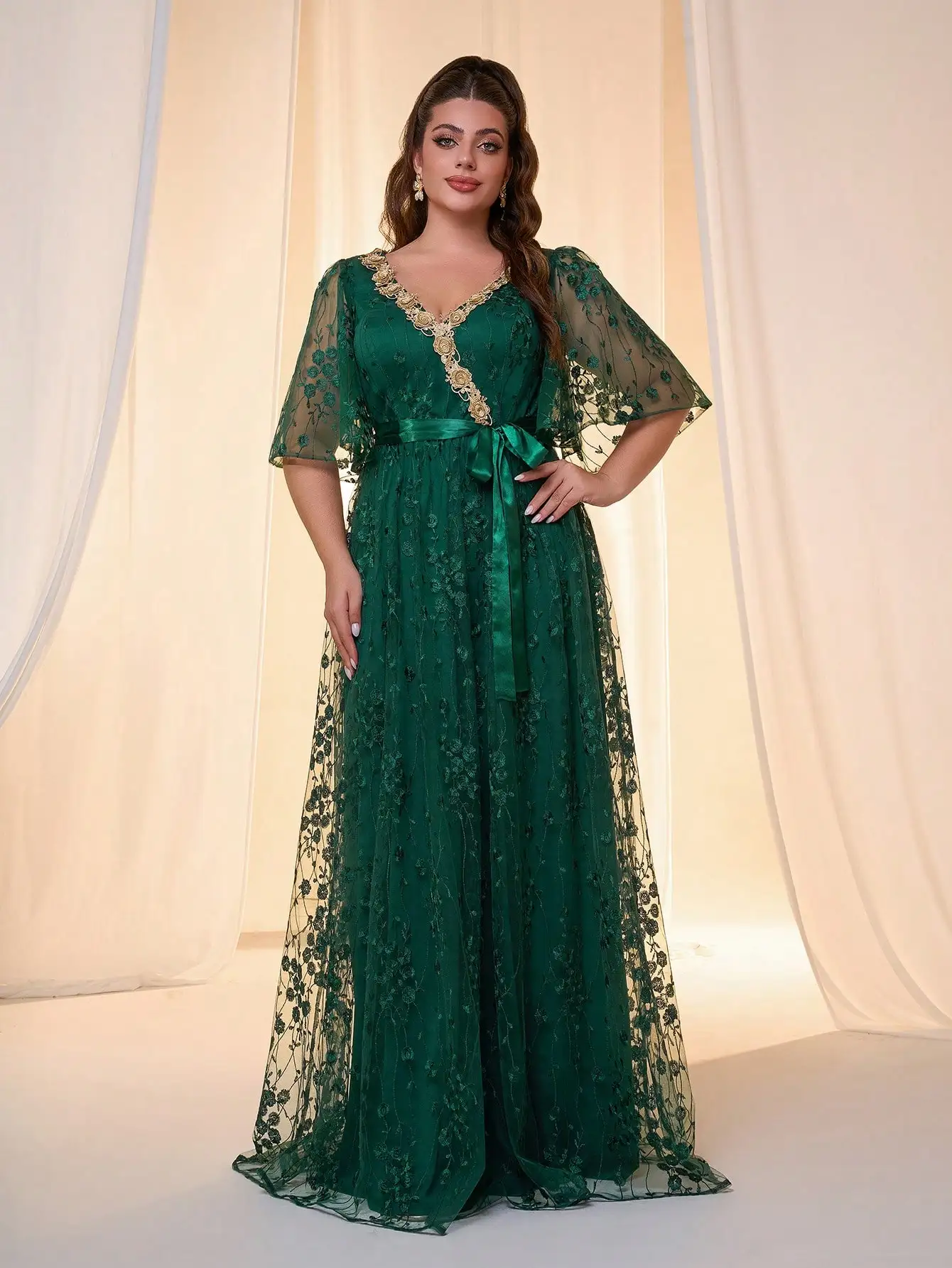 A V-neck, irregularly crossed flared sleeves, three-dimensional lace, colored tonal waistband, and a long skirt with a large hem