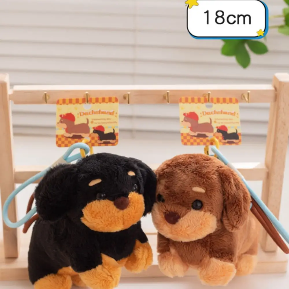 Cute plush dachshund dog keychain and furry puppy bag pendant hanging from a backpack handle.