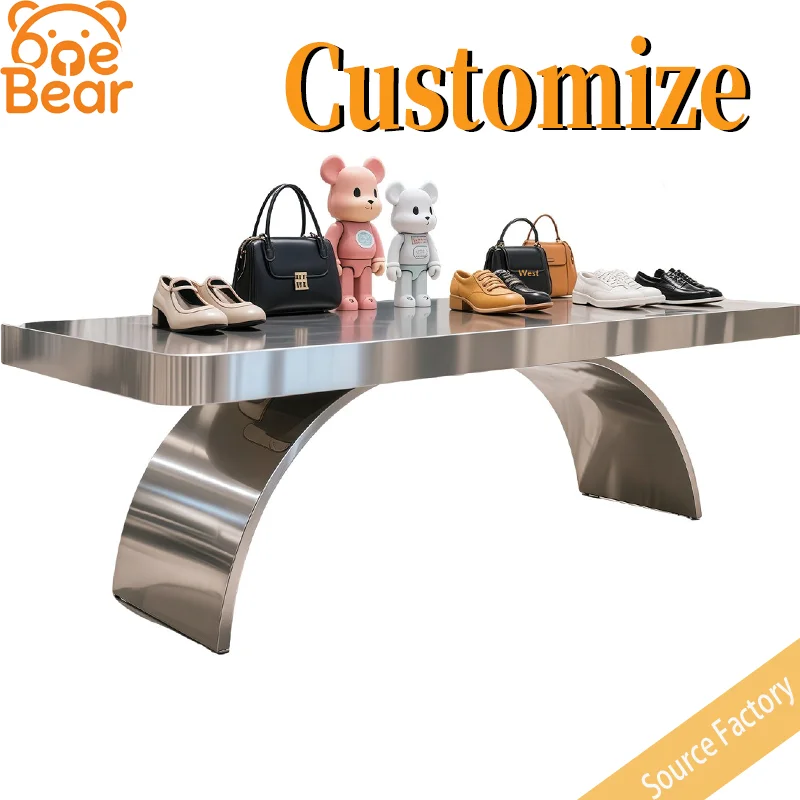 A stainless steel display table with decorative items arranged in the center, featuring a display shelf.