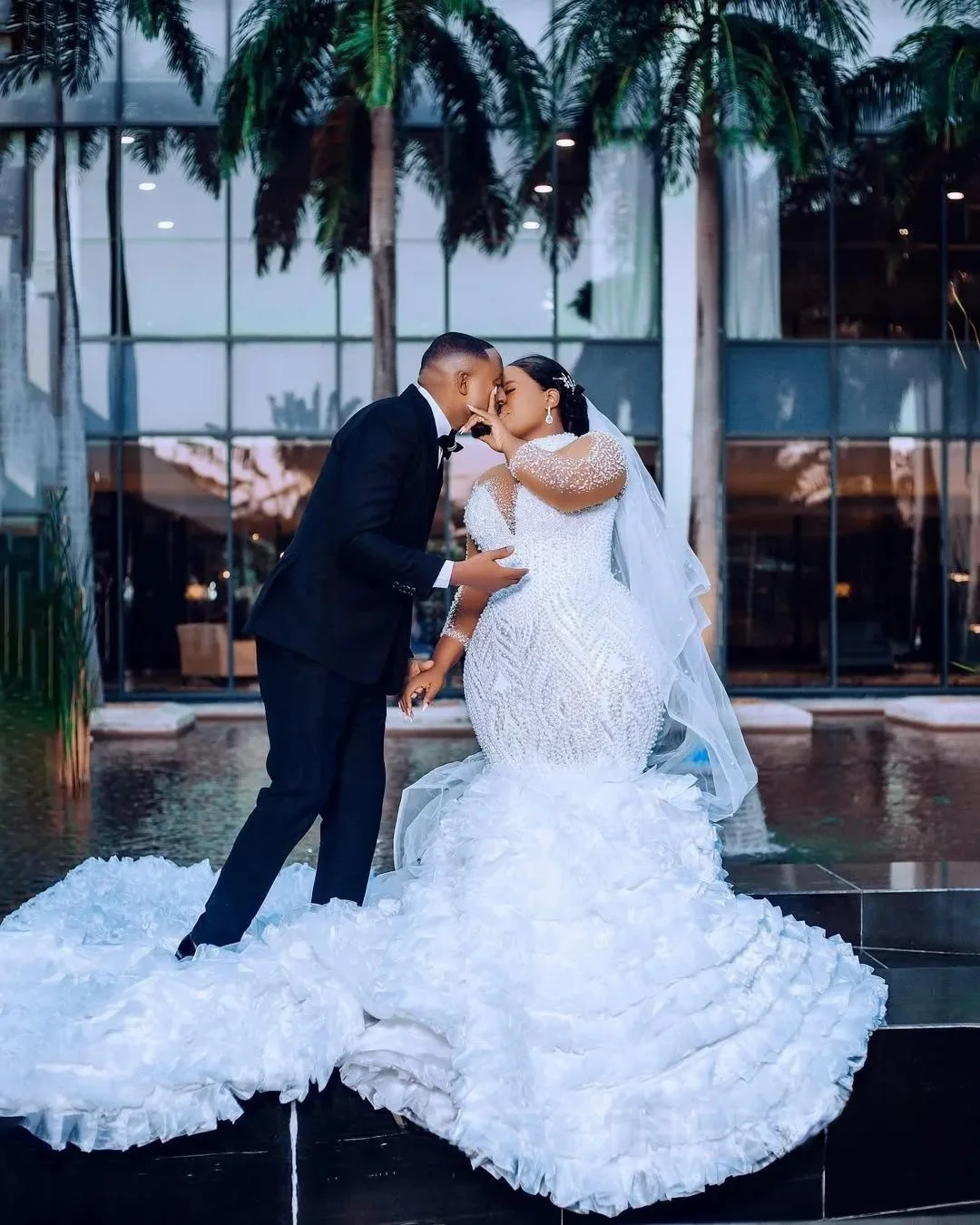 Suknia ślubna na zamówienie, biała, afrykańska, dla panny młodej, krój syreny, długie rękawy, zdobiona perłami i koralikami.