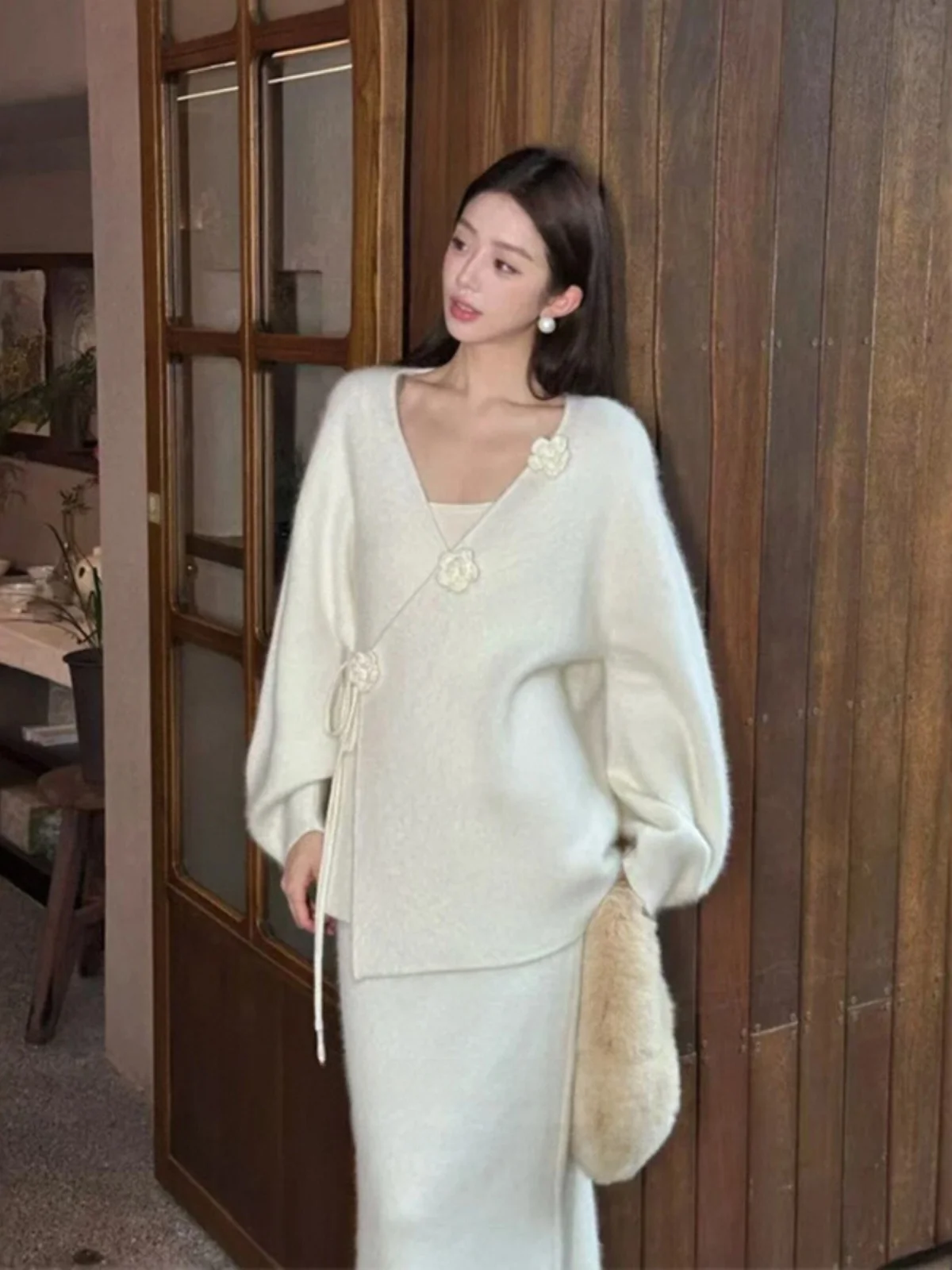 

Женский зимний вязаный комплект: свитер свободного кроя с V-образным вырезом и пушистой цветочной вышивкой, а также юбка-полусолнце. Костюм-двойка для женщин среднего возраста.