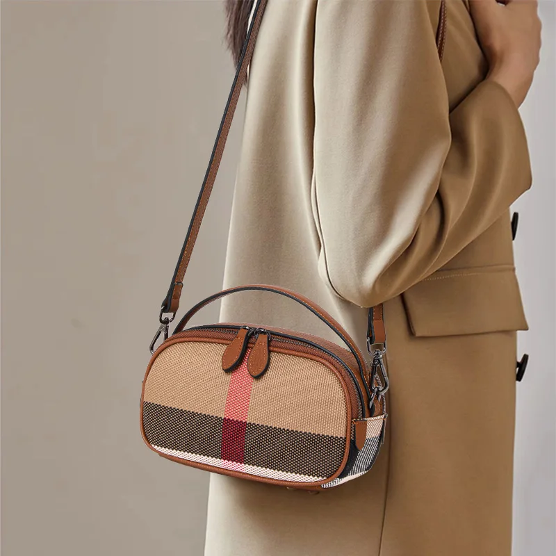 

Crafted from canvas cowhide material, Aidrani's brown checkered round women's single shoulder crossbody bag