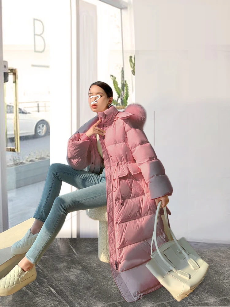 เสื้อโค้ทขนเป็ดสีชมพูแบบมีฮู้ดคลุมเข่าสำหรับผู้หญิง แฟชั่นใหม่ คอปกขนเฟอร์ขนาดใหญ่ สำหรับฤดูหนาว ทรงเข้ารูปช่วงเอว