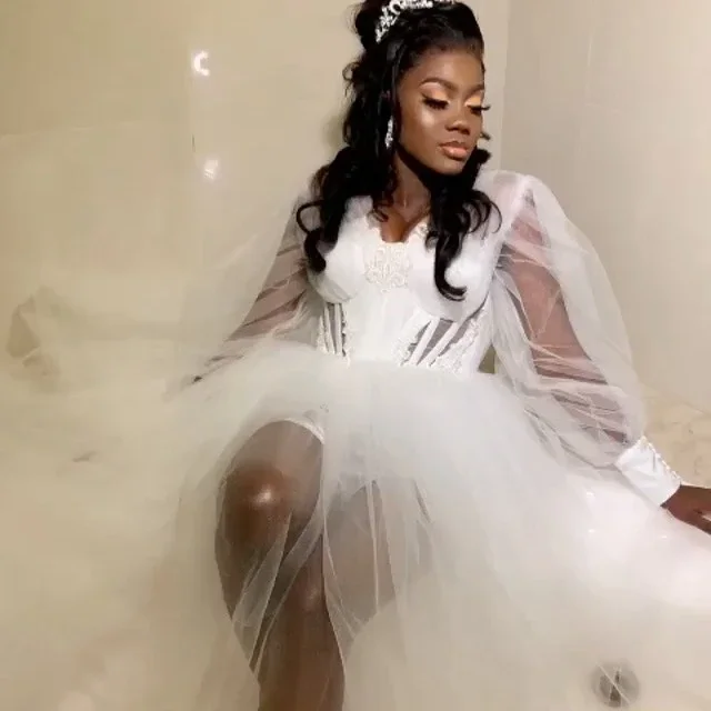 Suknia ślubna w kształcie litery A z dekoltem w serek, tiulowa, z długimi rękawami typu lampion, prześwitująca, z rozcięciem, idealna na przyjęcie weselne.