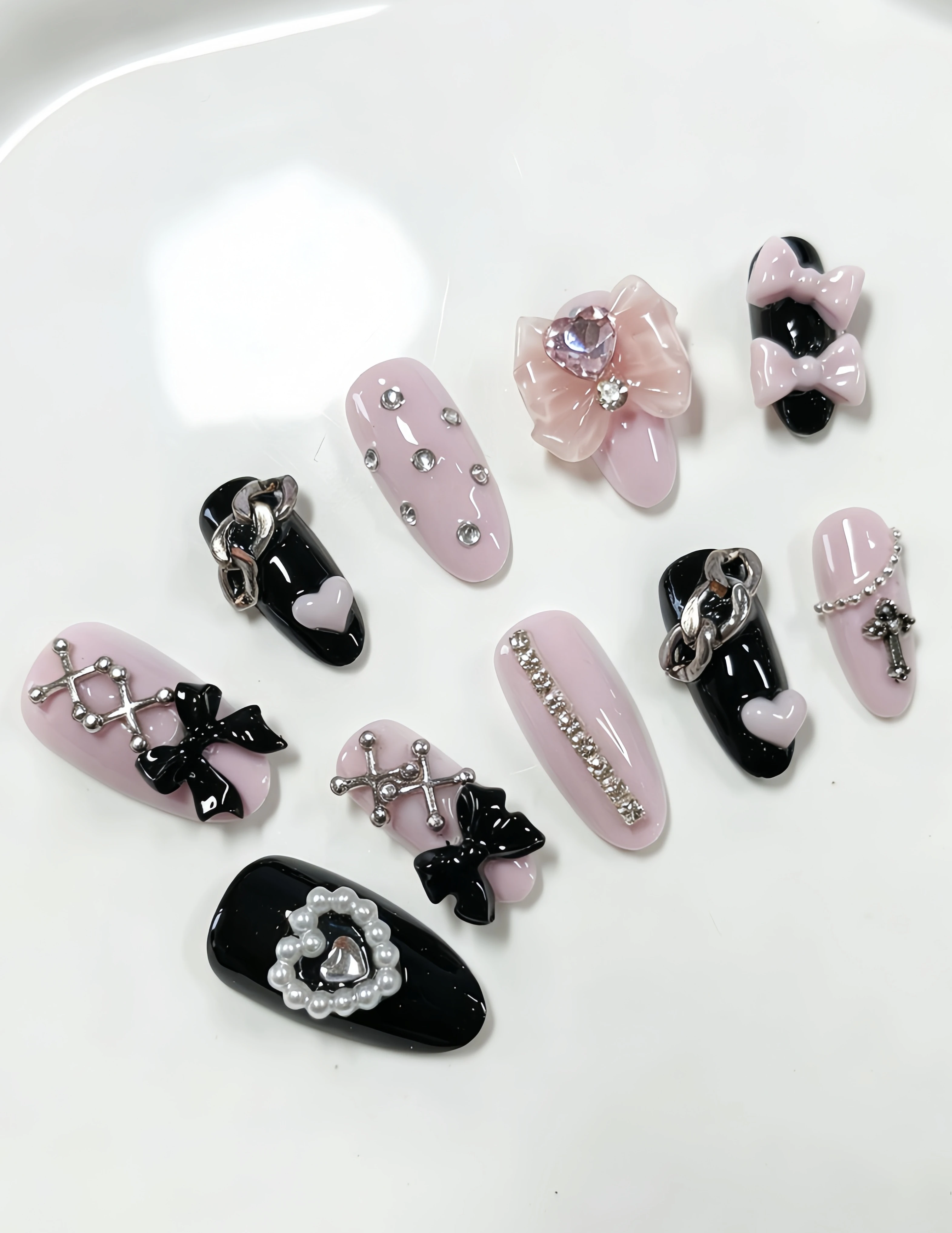 10 Almond-Shaped Nails, with Pink and Black as the Main Colors, Decorated with 3D Bowknots, Heart-Shaped Rhinestones, Cross Beads, Silver Ornaments, Heart-Shaped Pearls, Etc. Y2K Sweet-Cool Style Press-On Nails, Suitable for Students, Office Workers, Sweet Girls, and Those Who Love Sweet-Cool Fashion. Press-On Fake Nails Suitable for Daily Outings, Campus Life, Bars, Clubbing, Vacation Season, Parties, Birthday Banquets, Etc. Comes with a Jelly Glue and a Nail File