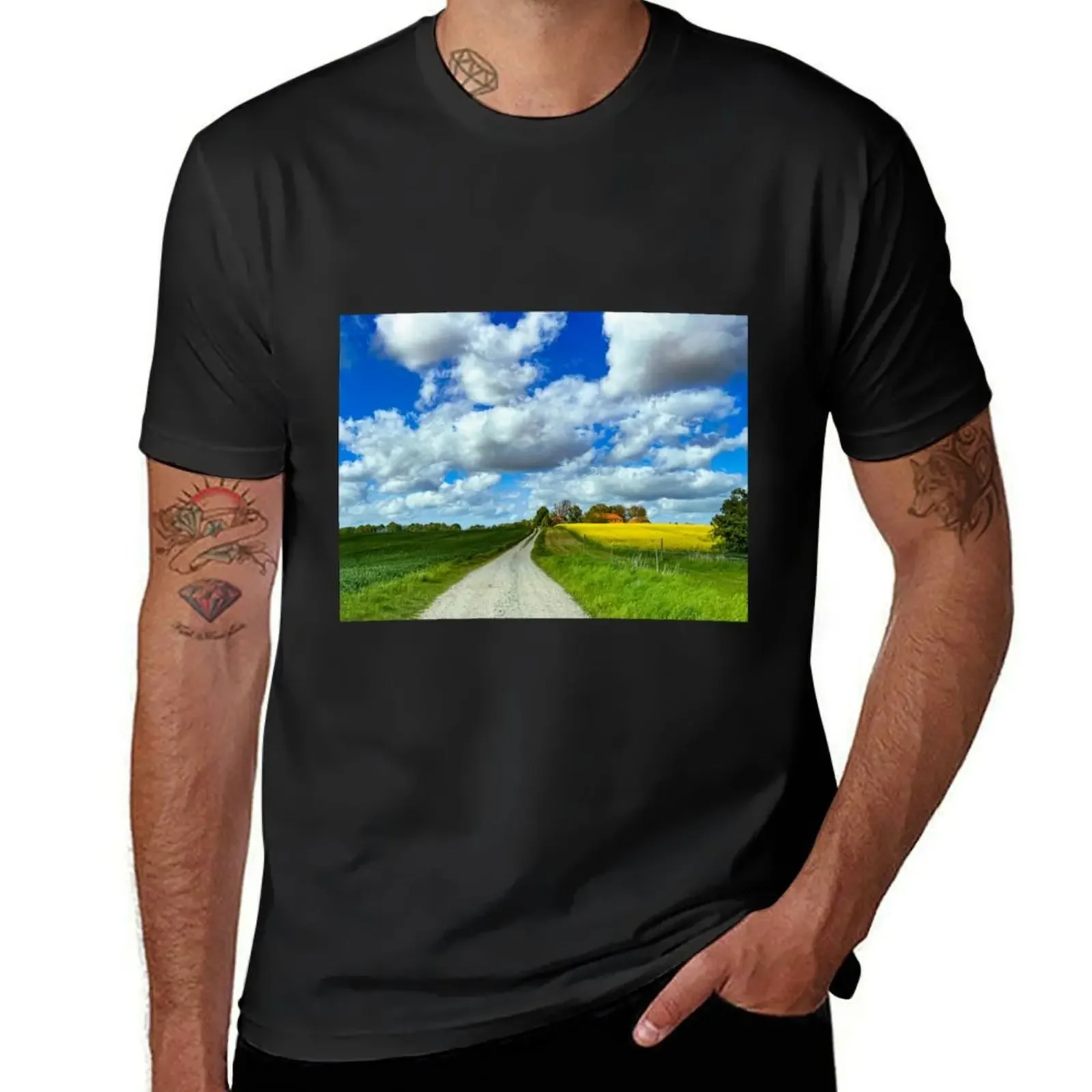 Country lane leading to a manor with a yellow canola field under a blue sky T-Shirt sweat men clothes