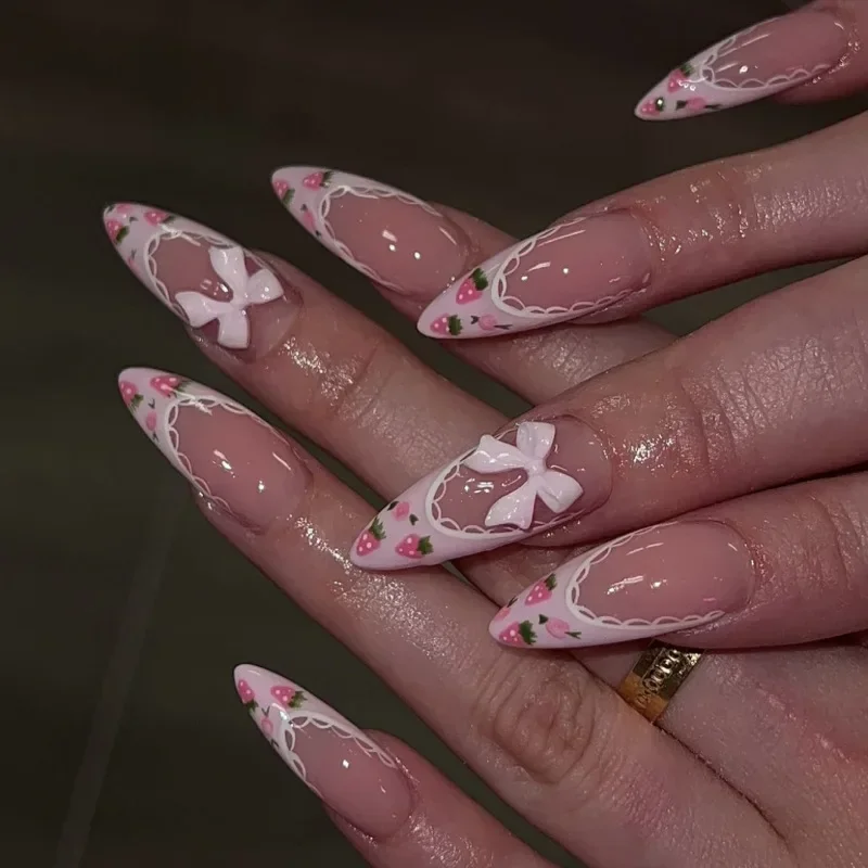 ピンクホワイトのリボン結び、キラキラ光るラインストーン、フレンチパール、ヌードアーモンド型の付け爪、ミディアムポインテッドのつけ爪、プレスオンネイル、マニキュア