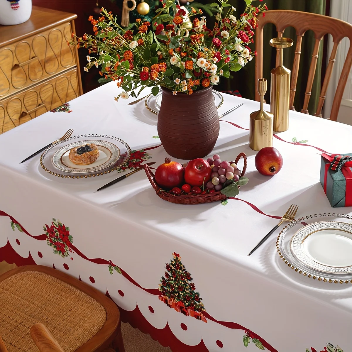 A Christmas tablecloth with red Christmas garlands and a Christmas tree