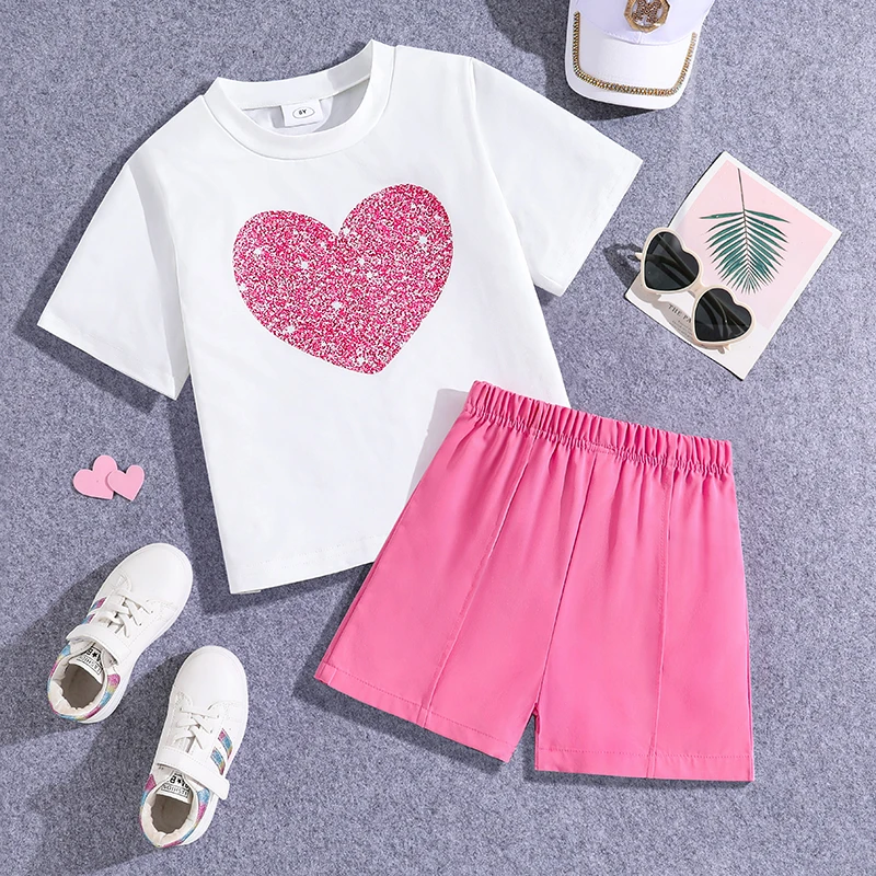 

Повседневный комплект из 2 предметов для девочек 8-12 лет: белая футболка с блестящим розовым принтом в виде сердечек и розовые шорты с эластичной резинкой на талии, милый вариант для повседневной летней носки