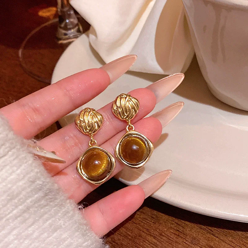 Golden earrings featuring tiger eye stones, with an extremely bold design. Suitable for women to wear in autumn and winter, for