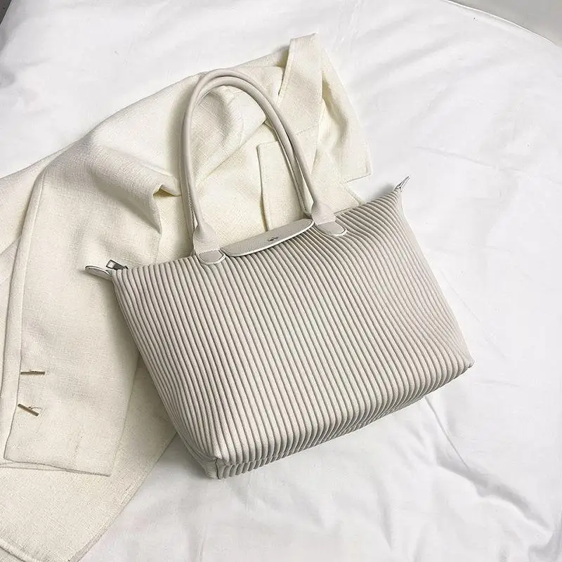 

Crinkled 2023 It-Bag. Featuring understated elegance & a unique pleated design. Your new favorite crossbody/tote.