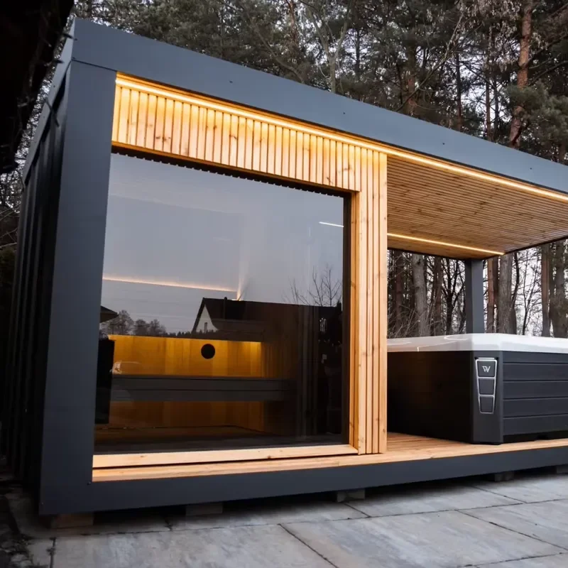 Modern outdoor sauna with integrated terrace and LED lighting, grey exterior, no bathtub