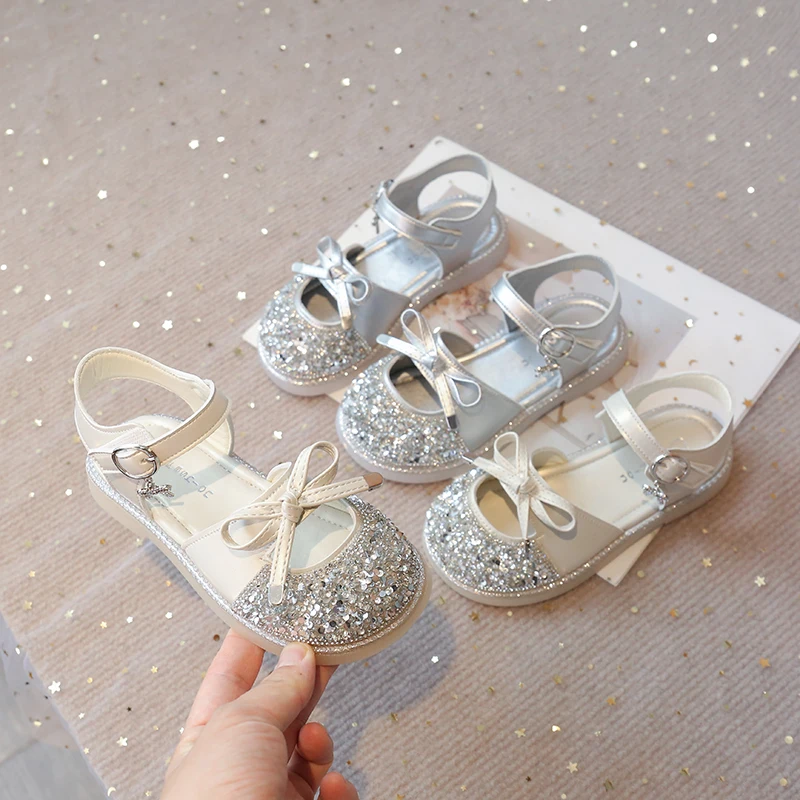 

Детские сандалии для девочек с блестками и стразами, с вырезами, на плоской подошве, мягкие, модные, в стиле принцессы, с милым бантом и пайетками, пляжные, с защитой от ударов