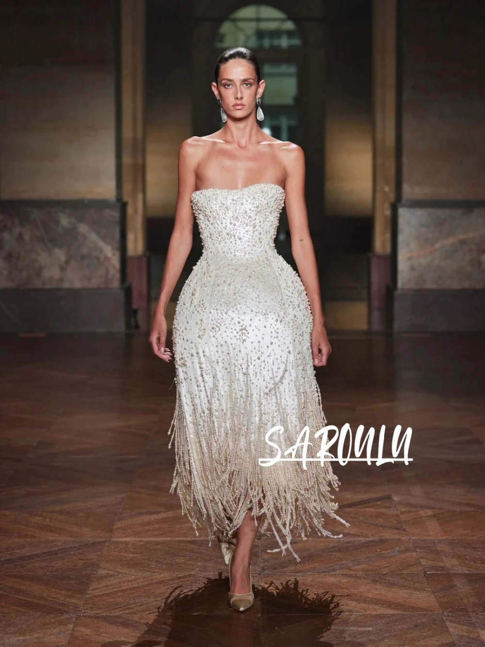 

Роскошное вечернее платье с белыми жемчужинами и бахромой, идеальное для свадьбы, вечеринки или торжественного мероприятия.