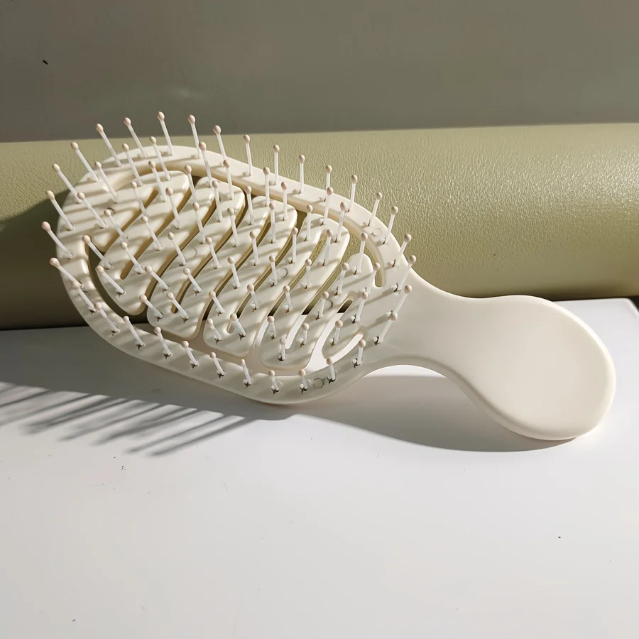 Mini Track Hairbrush, portable hollow design with nylon bristles, ergonomic handle, compact and lightweight—a travel essential.