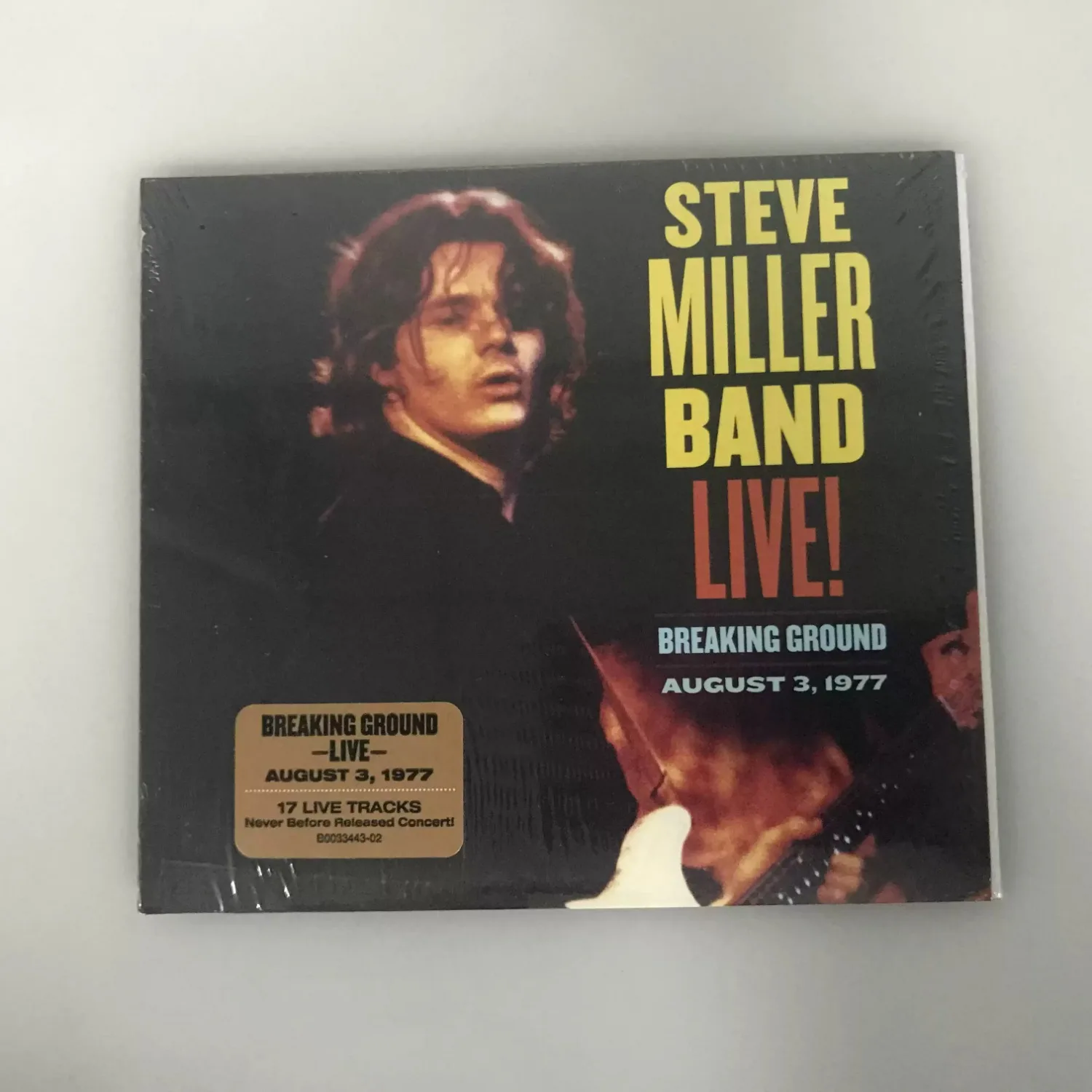 CD de Blues Rock Americano de los años 70, con fondo oscuro, portada de retrato vintage de escenario, disco de grabación en vivo premium coleccionable sin publicar