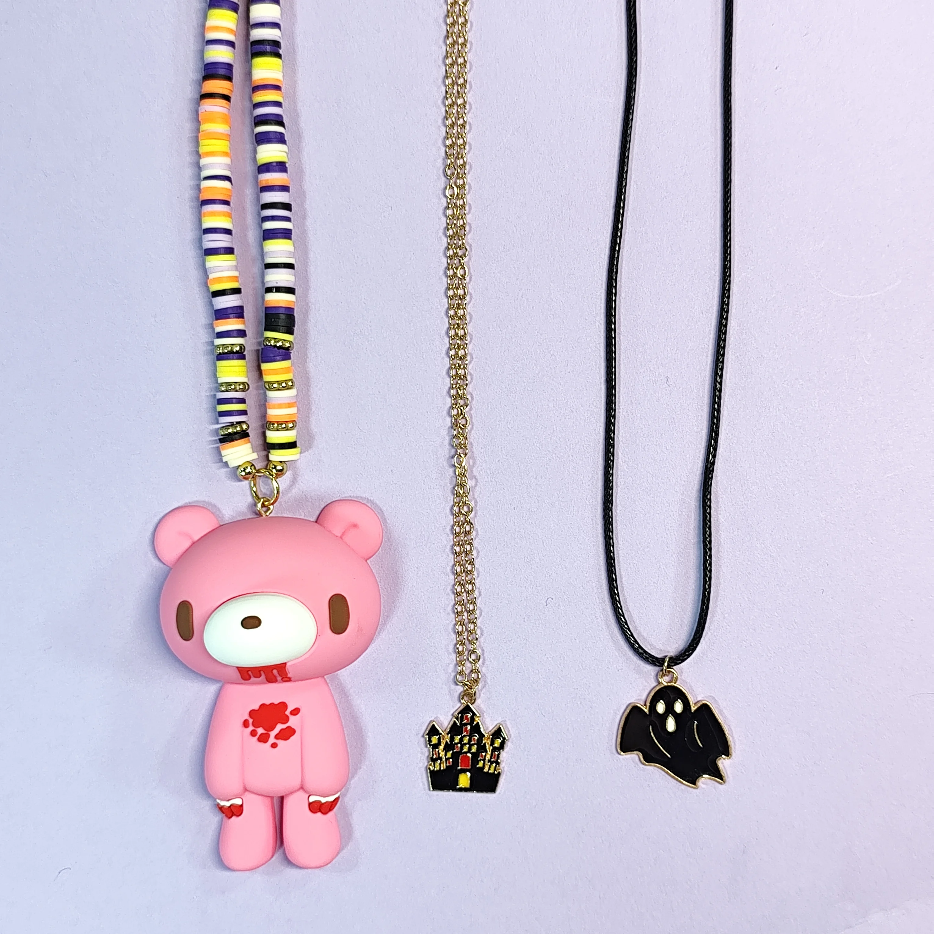 Layered necklaces with cute bear pendants (pink/white), beaded chains, and Halloween - themed charms. Edgy yet adorable.