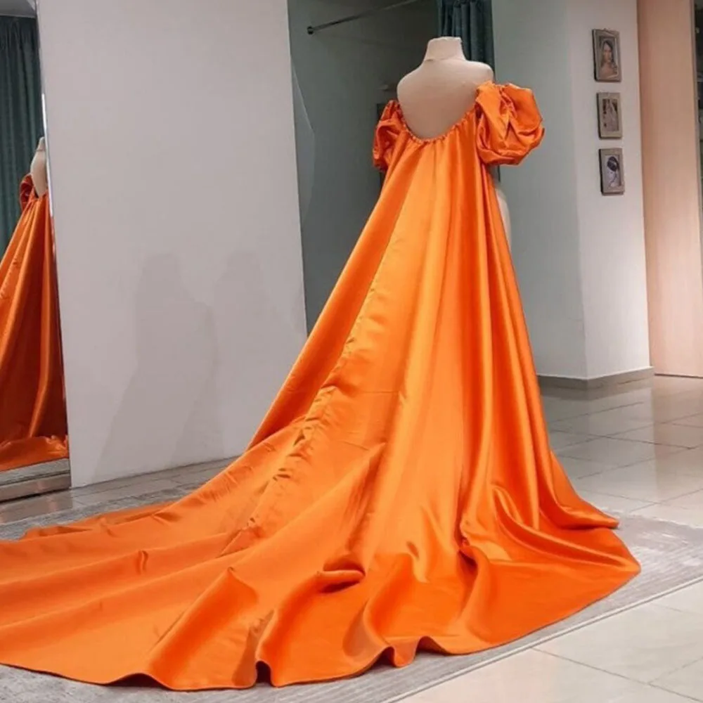 กระโปรงผ้าไหมสีส้มสดใสพร้อมแขนพองและรถไฟยาว เหมาะสําหรับงานเป็นทางการและพิธี ผ้าเรียบลื่น