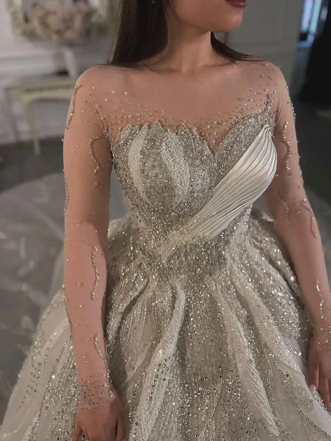 Eleganckie suknie ślubne z kryształami, prześwitujący dekolt, długi rękaw, odpinany tren, zdobione koralikami, szyte na miarę.