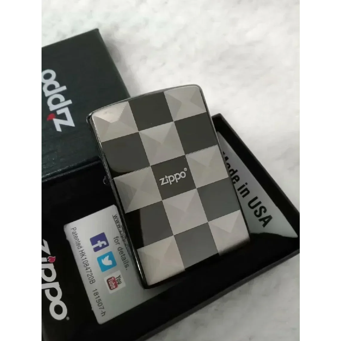 Briquet zippo style à carreaux noir et blanc dans une boîte