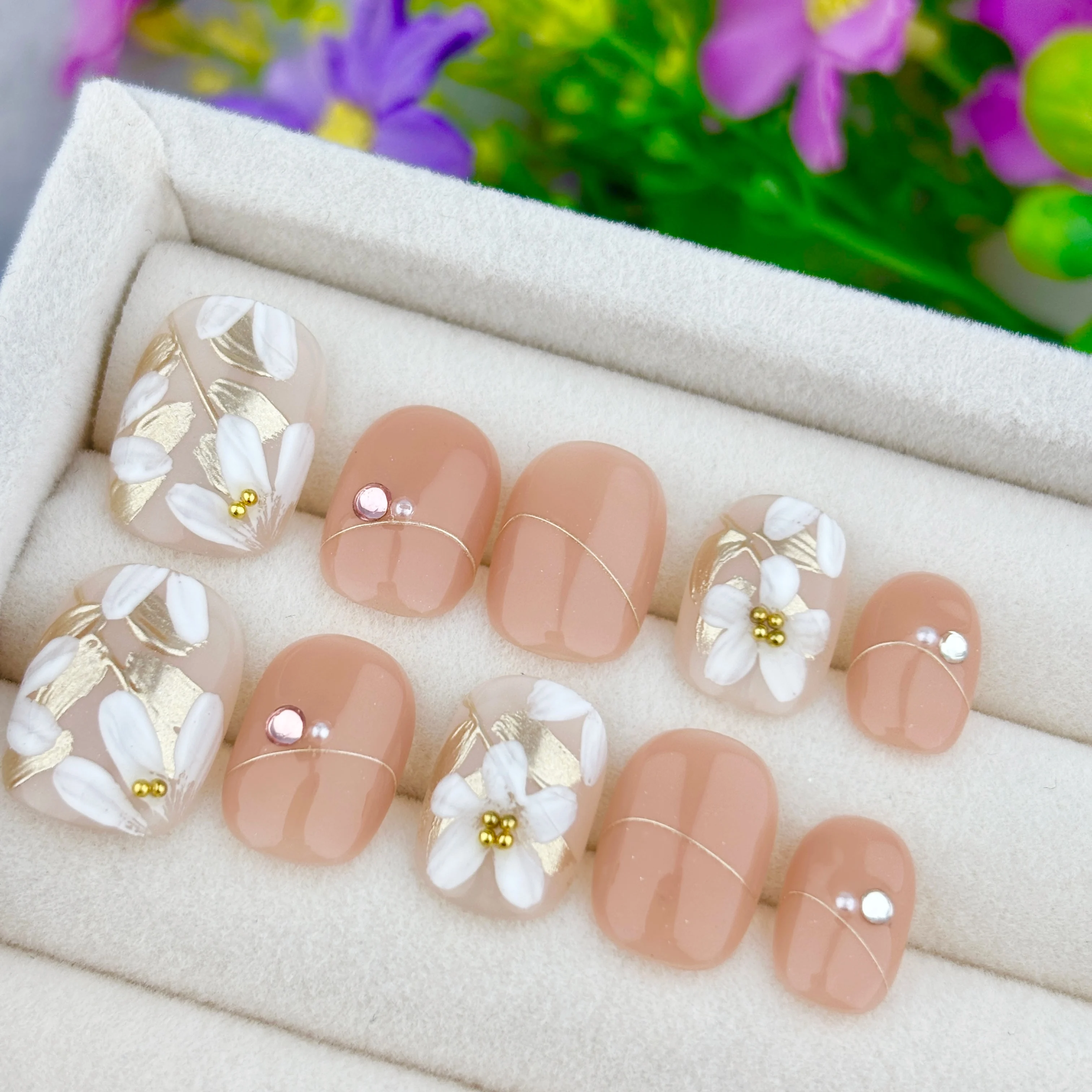 Exquisite handgefertigte kurze runde Press-On-Nägel, hochwertige Nude-Kunstnägel, verziert mit handbemalten weißen Blumen, Goldfolie und Strass, sanfter floraler Stil, wiederverwendbare kurze Nägel