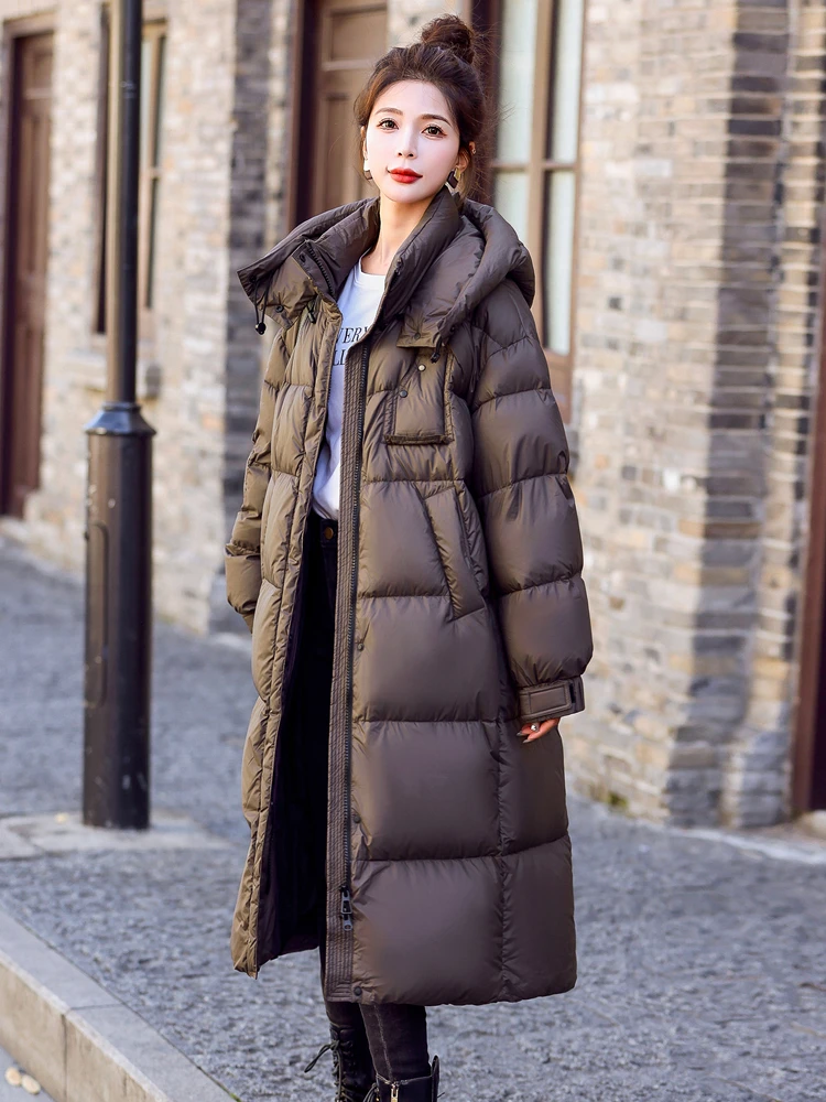 女性のミドル丈の白いダックダウンジャケット、ゆったりとした厚い暖かいジャケット、冬
