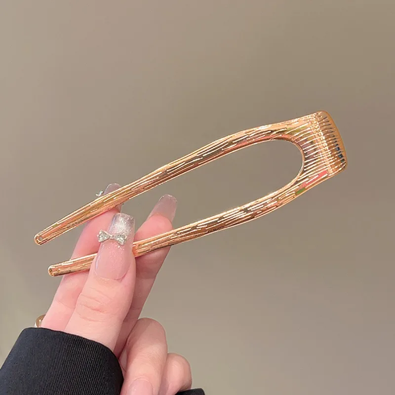 금속 참 장식의 꼬임 패턴과 매끄러운 교차로 엮인 U자형 브로치가 세련된 드레싱 스타일을 빛내며, 독특하면서도 고급스러운 느낌을 선사합니다.