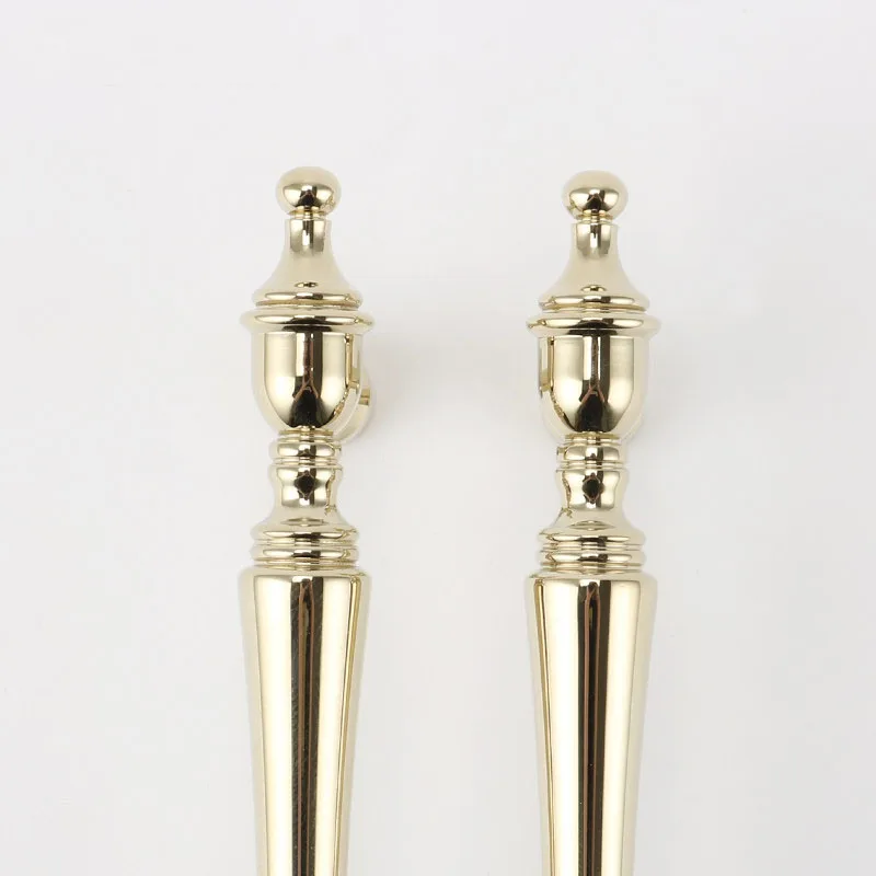 Detailed shaped end of a gold brass furniture pull