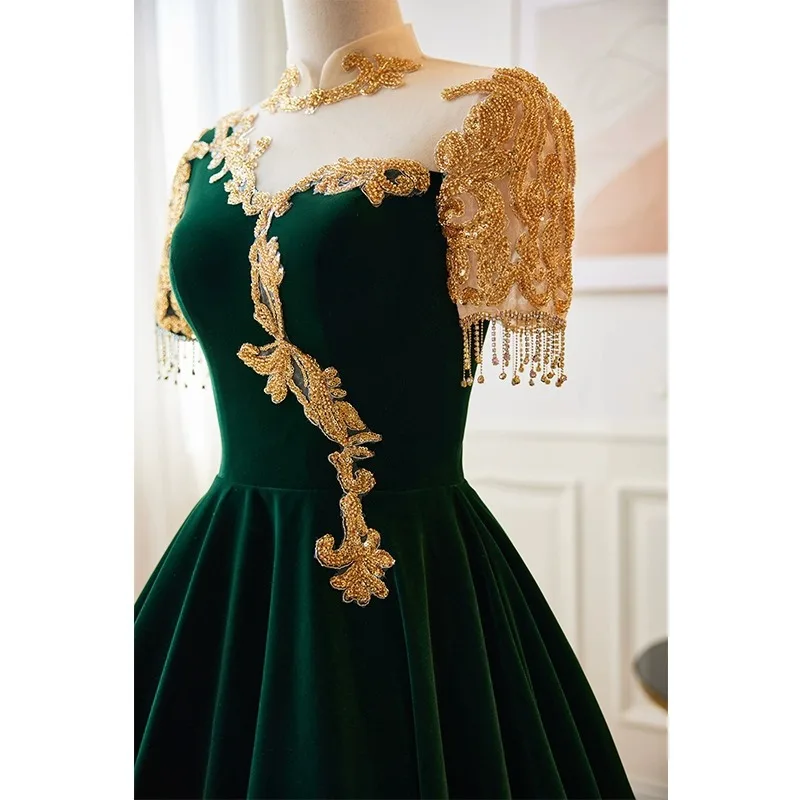 Ciemnozielona suknia wieczorowa, damska suknia na występ fortepianowy, elegancka atmosfera, wyszukana suknia do występów folkowych.