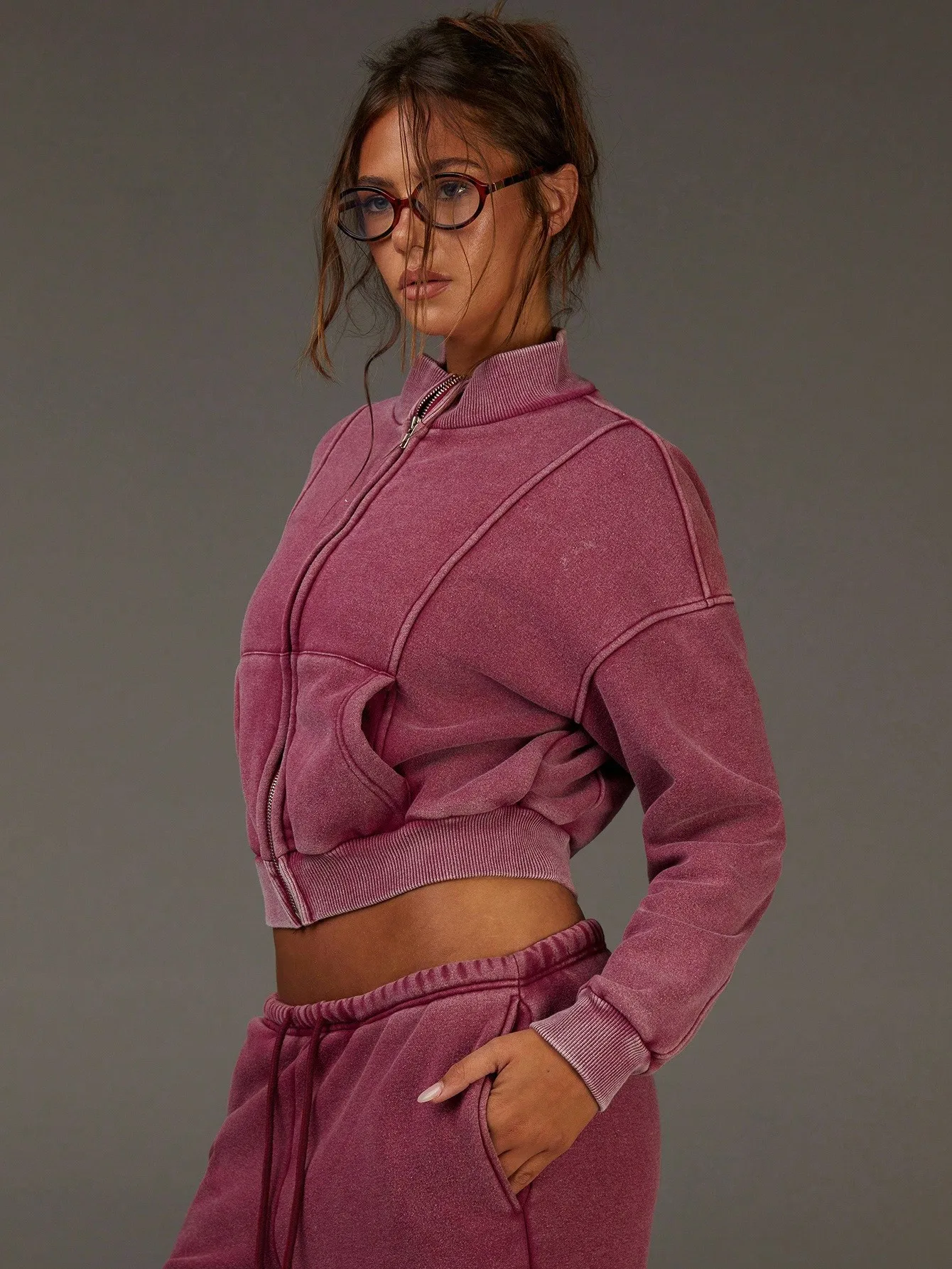 Damska kurtka w kolorze magenta, w stylu vintage, z prążkowanym materiałem, zapinana na zamek, z ozdobnymi przeszyciami, krótka, idealna do codziennego streetwearu.