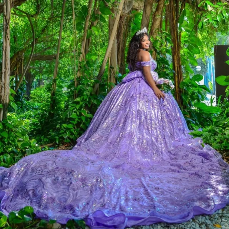 فستان Quinceanera أرجواني مكشوف الأكتاف من الدانتيل اللامع بفيونكة طويلة وذيل طويل فيستدوس دي 15 Quinceanera ﻿ تخصيص