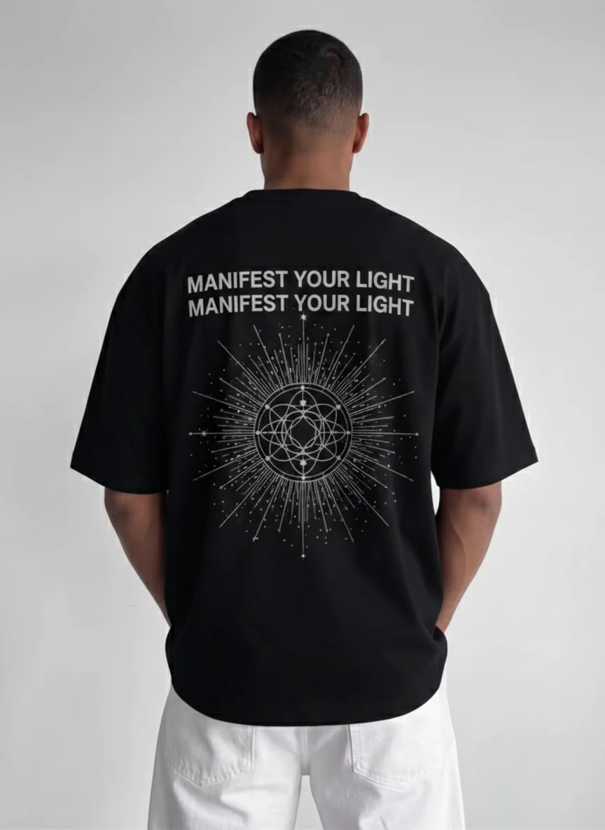 

Black Sacred Geometry Graphic Tee with White Starburst Mandala and Manifest Your Light Text Printed on the Back Unisex Printed Tee