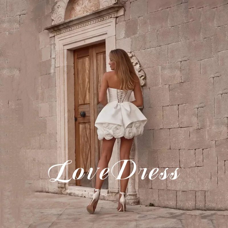 モダンなステインアイボリーのウェディングドレス ストラップレス ノースリーブ ボールガウン プリーツフラワー セクシーなバックレス レースアップ ショートドレス カスタマイズ