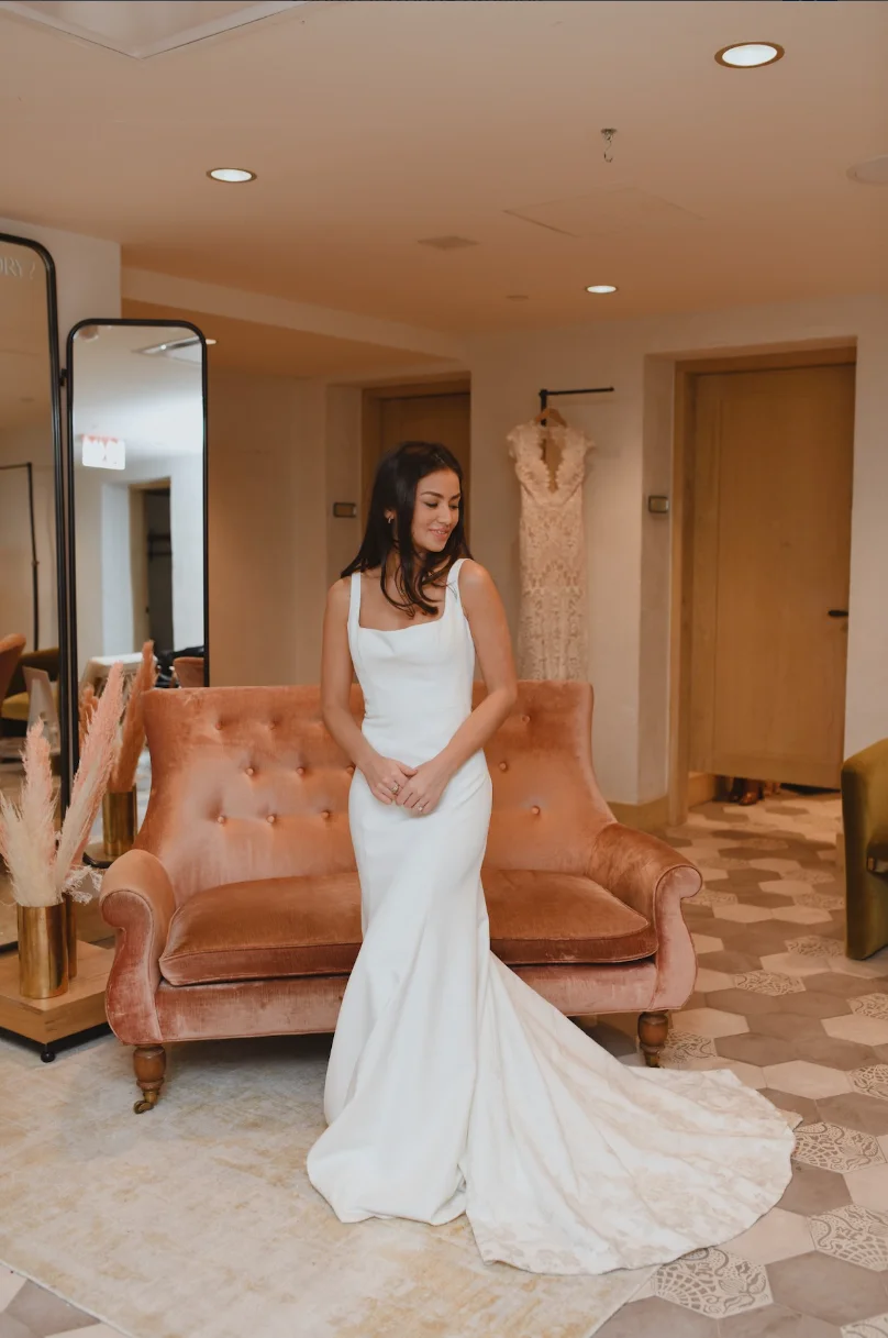 Sleek square-neck dress with wide straps, low open back trimmed with delicate lace, button closure, and elegant train
