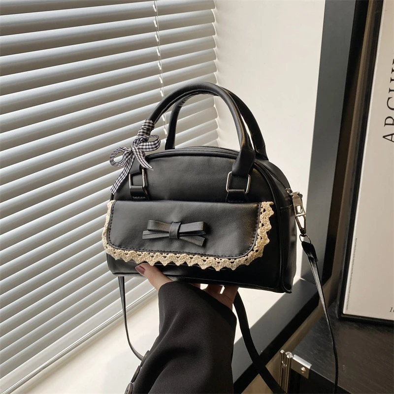Eine vielseitige, handgehaltene Boston-Tasche mit Fliege für Damen in 2025, koreanische Version, eine modische, süße und lässige Umhängetasche