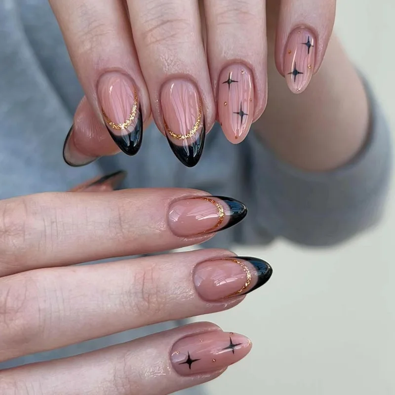 Mittellange künstliche Nägel für Frauen im französischen Stil, nude Mandel-Nagelspitzen mit schwarzen Sternen, roten Farben und glitzernden goldenen Streifen, zum Aufkleben.