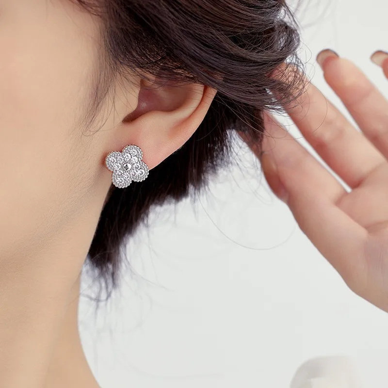 Um luxuoso trevo de quatro folhas de cobre incrustado de diamantes com um colar é streaming ao vivo por uma mulher