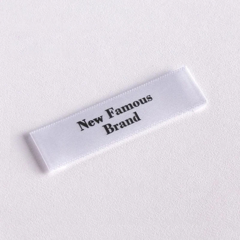 50 قطعة من ملصقات الملابس الساتان المخصصة - علامة محتوى الرعاية، 100% بوليستر، أسود/أبيض، مقاسات متعددة، ملصق قماش الخياطة OEM