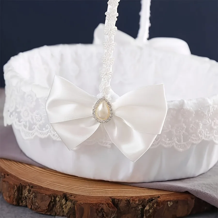 A floral basket with wedding candies, scattering flowers, and a beautiful large bow for the white flower girl.