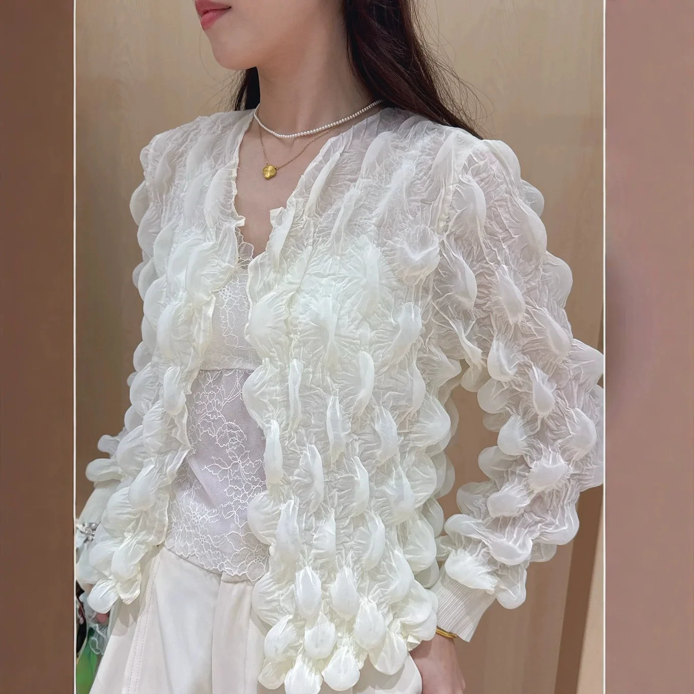 A stylish, loose-fitting, solid-color, versatile cardigan with a unique, design-conscious puff-pleated style.