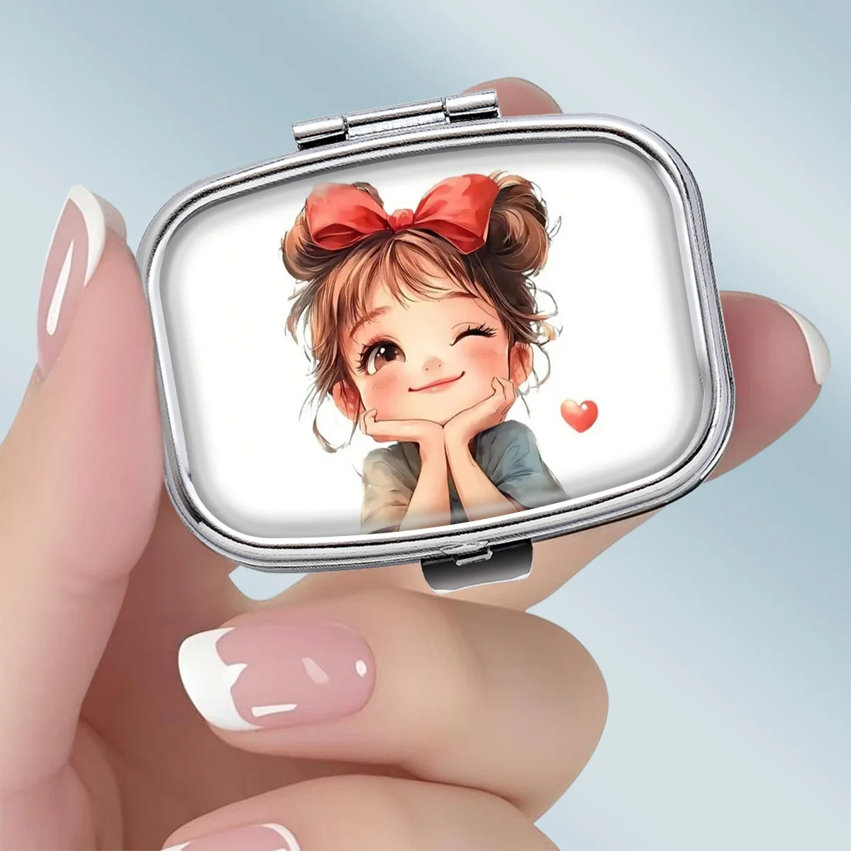 A Portable Square Metal Pill Box with a Playful Wink-Wink Lady Theme, Featuring 2 Compartments, Perfect for Elegantly Storing Your Medications or Supplements. It Is Perfect for Sorting Vitamins and Storing Small Items.