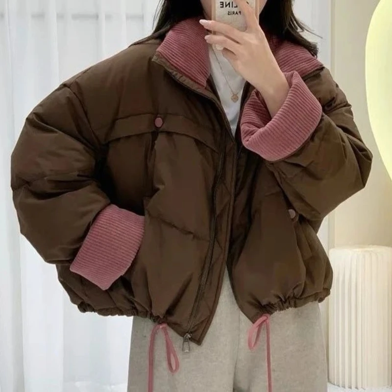 การปิดกั้นสียืนขึ้นปกเสื้อแจ็คเก็ตสั้นสําหรับผู้หญิงในฤดูหนาว 2025 ใหม่แจ็คเก็ตขนมปังอบอุ่นหนาและหลวม