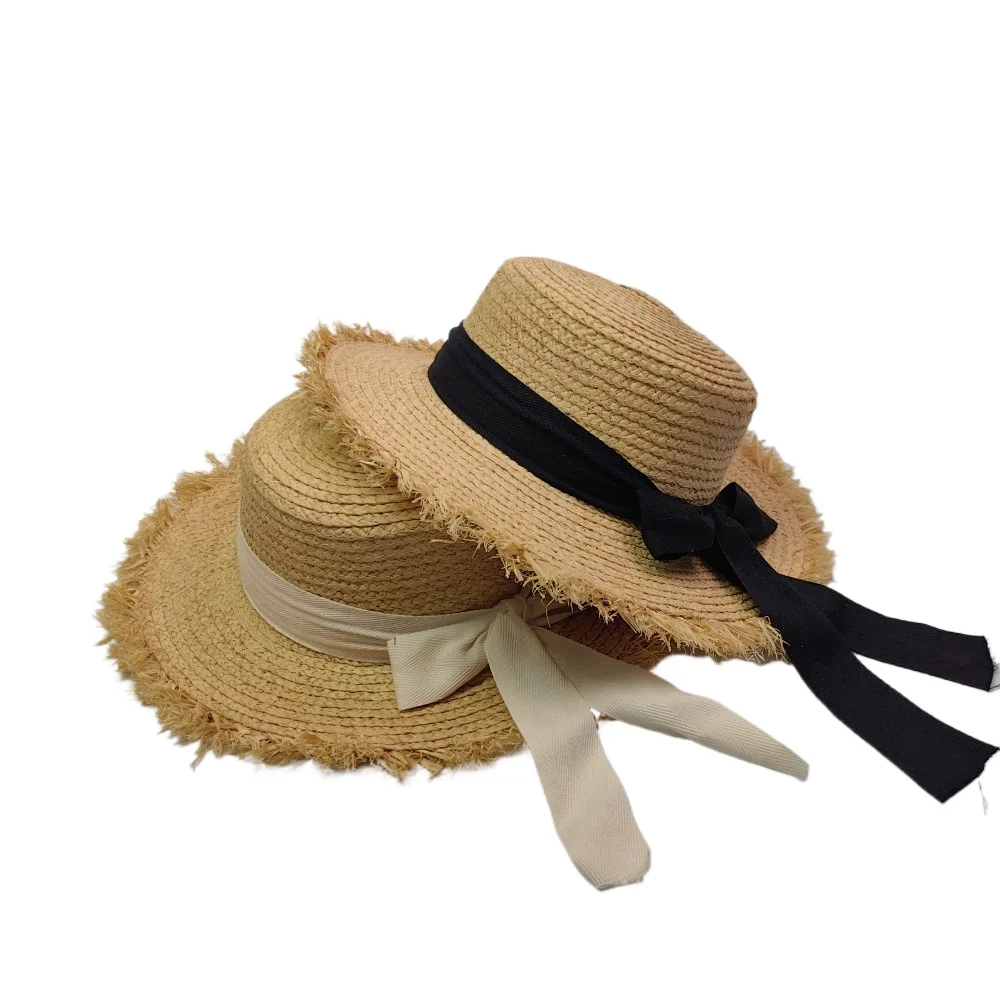 

Flat-top Rafi straw hat with wide brim and bow-shaped decoration for sun protection, suitable for beach and vacation wear.