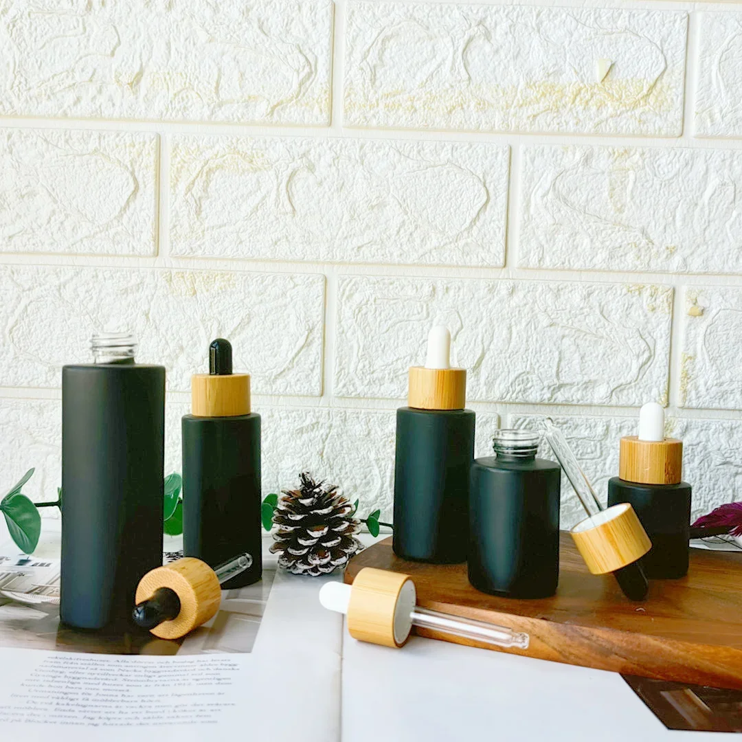 Botella cuentagotas de vidrio negro mate vacía, pedido a granel, aceites esenciales recargables de madera amboo, contenedores para el cuidado de la piel con tapa de bambú